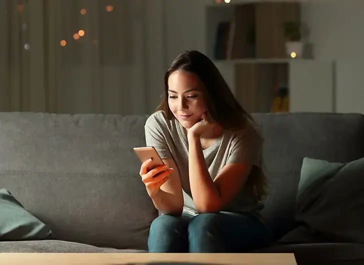 Femme gérant l'alarme de sa résidence secondaire à distance