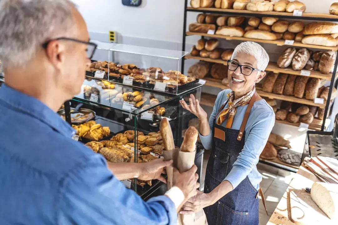 Boulangère accueillant un client dans son commerce