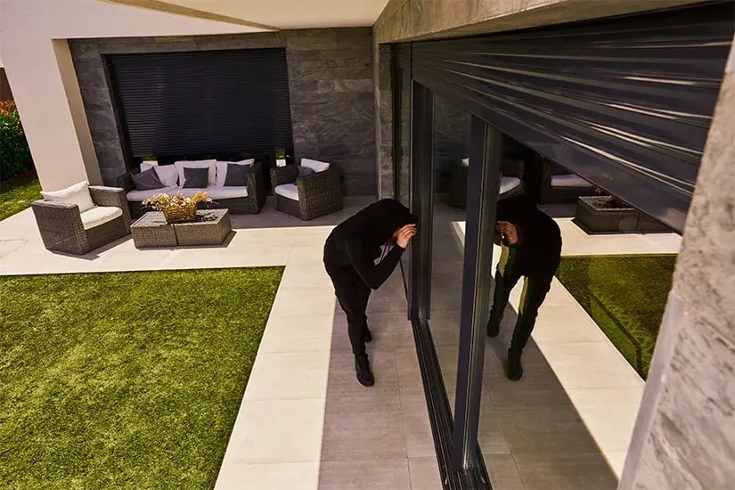 Cambrioleur sur une terrasse prêt à agir, illustrant le risque de cambriolage et le remboursement assurance sans facture