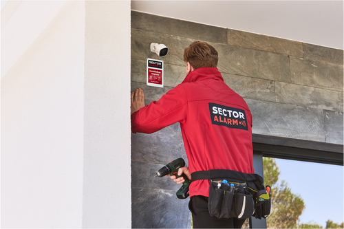 Installateur de Sector Alarm posant une caméra